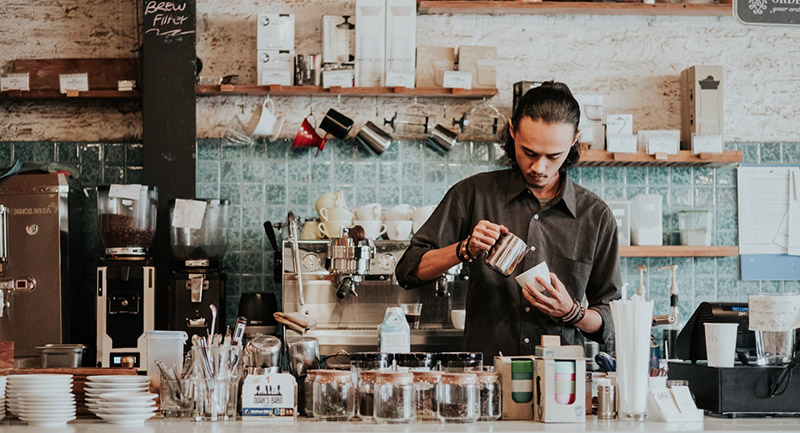 Barista pouring coffee into a cup